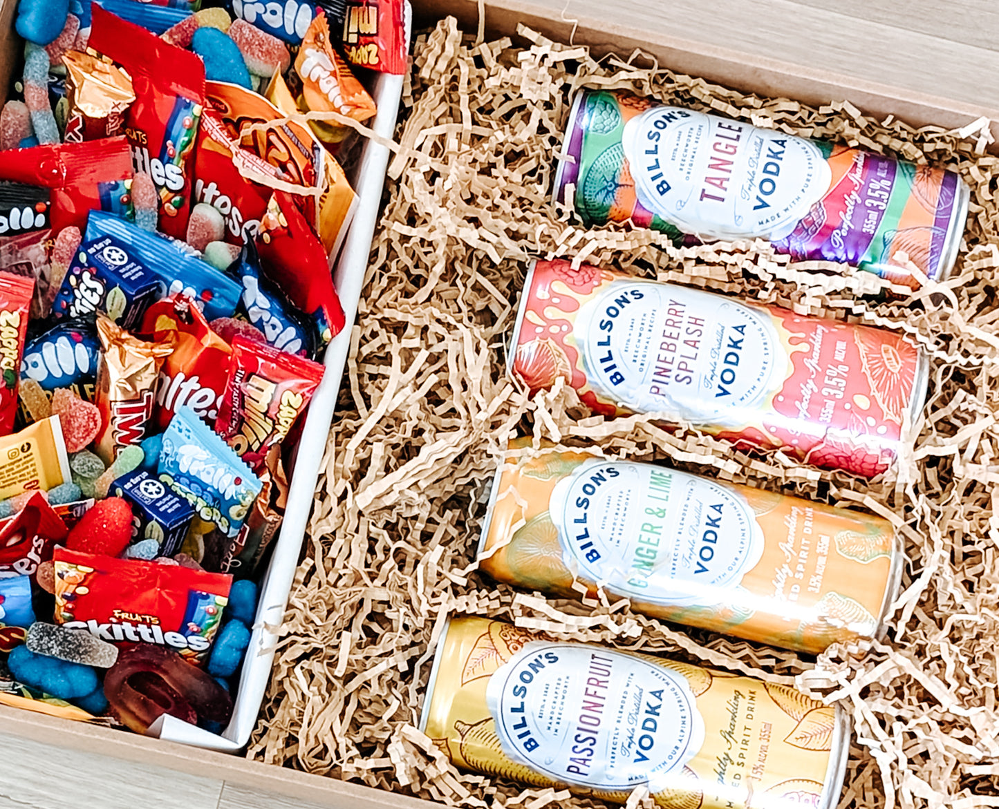 Photograph of dessert box featuring Billsons Vodka hamper with trolli lollies, skittles, whizz fizz, smarties, maltesers and twix.