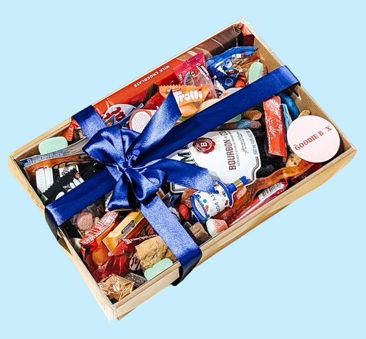 Photograph of male gift hamper that is neatly wrapped with a blue satin bow.