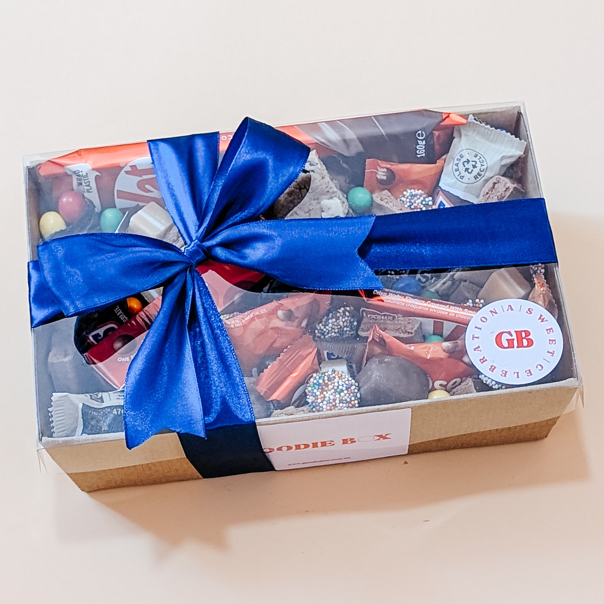 Photograph of a Chocolate Lovers Dessert Hamper elegantly wrapped with a blue bow, ready for gifting.