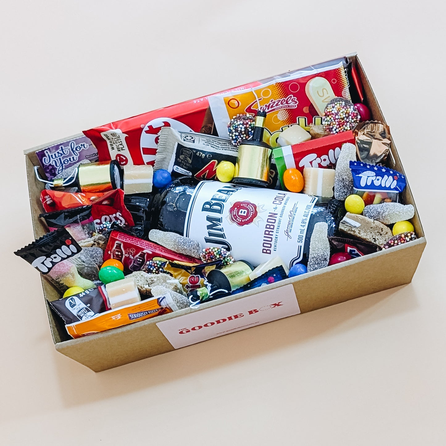 Photograph of gift hamper that includes Jim Beam Bourbon, cookies, tim tams, trolli lollies, whizz fizz and more.