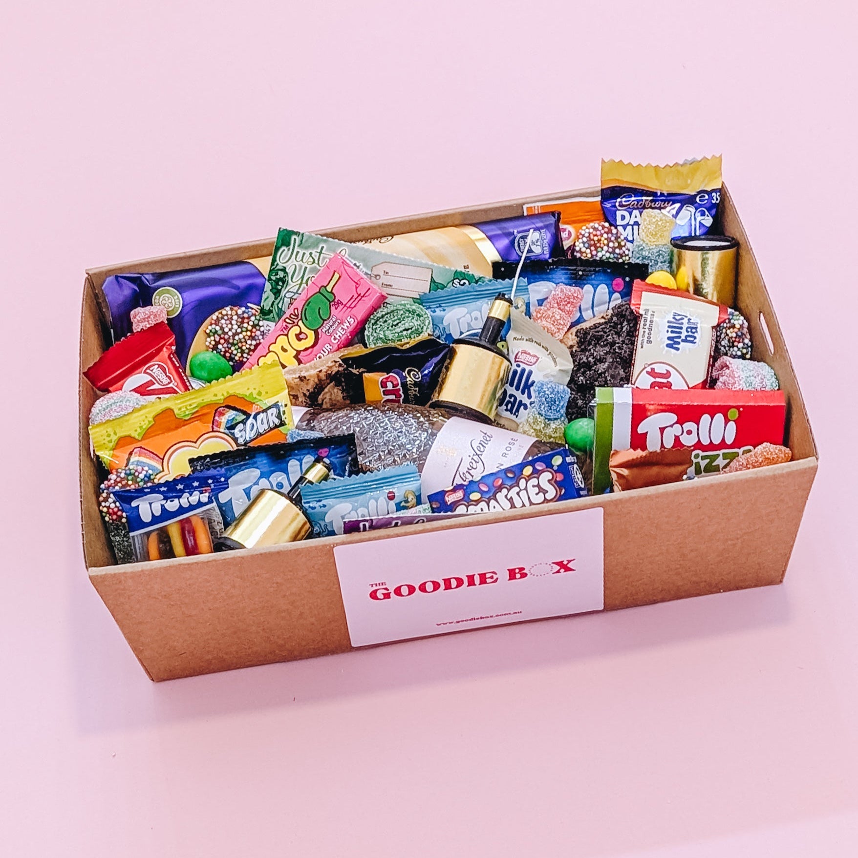 Photograph of dessert birthday box for her featuring sparkling wine, party poppers, chocolates, cookies and lollies.