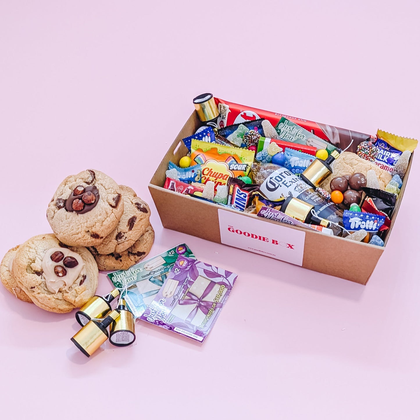 Photograph of gift box filled with Corona, Nerds, Cadbury Dairy Milk, Trolli Lollies and an assortment of mini chocolates and loose cookies and sweets.