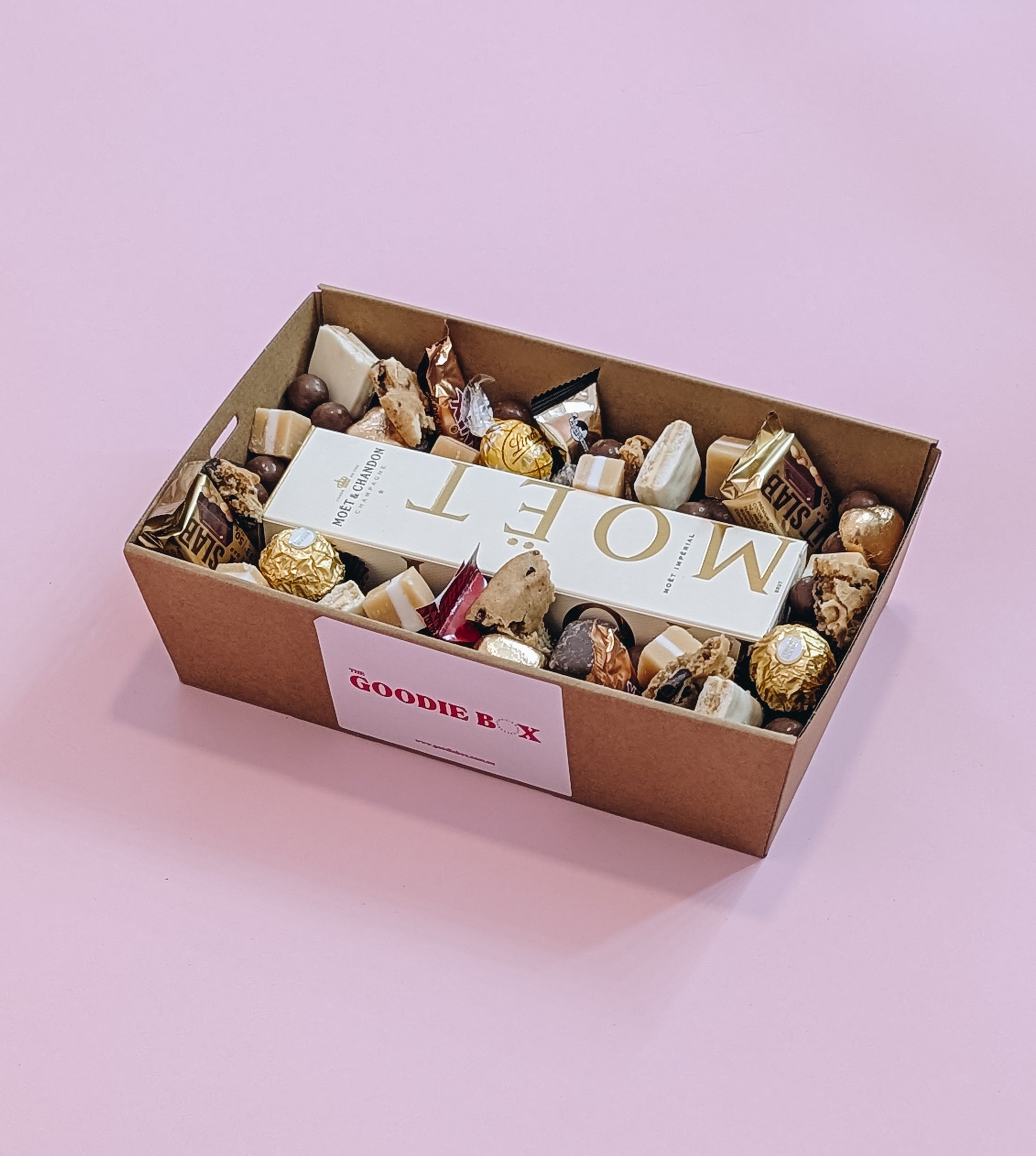 Photograph of Luxury dessert box hamper featuring Moët & Chandon Champagne and an assortment of loose and packaged chocolates.