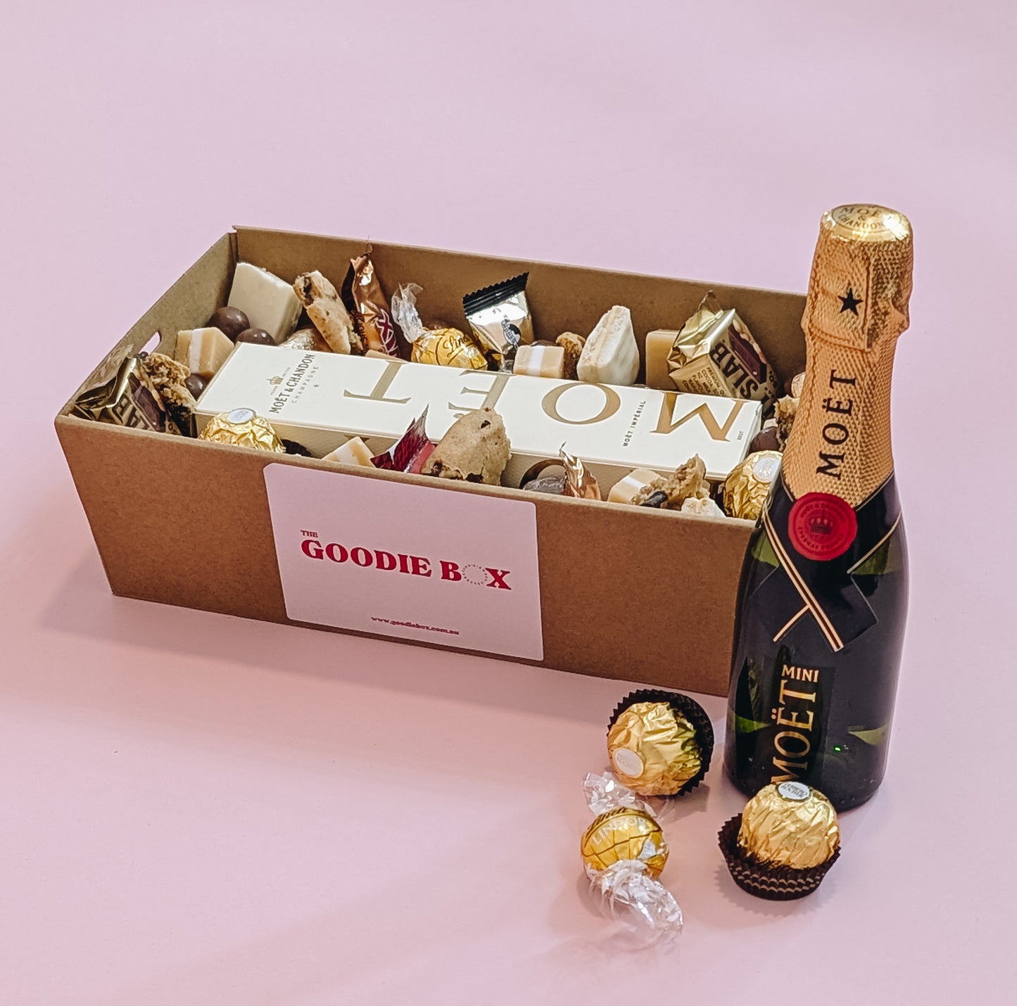 Photograph of Luxury Moët Champagne and chocolate gift hamper with personalized message. Wrapped with a beautiful gold bow ready for gifting.