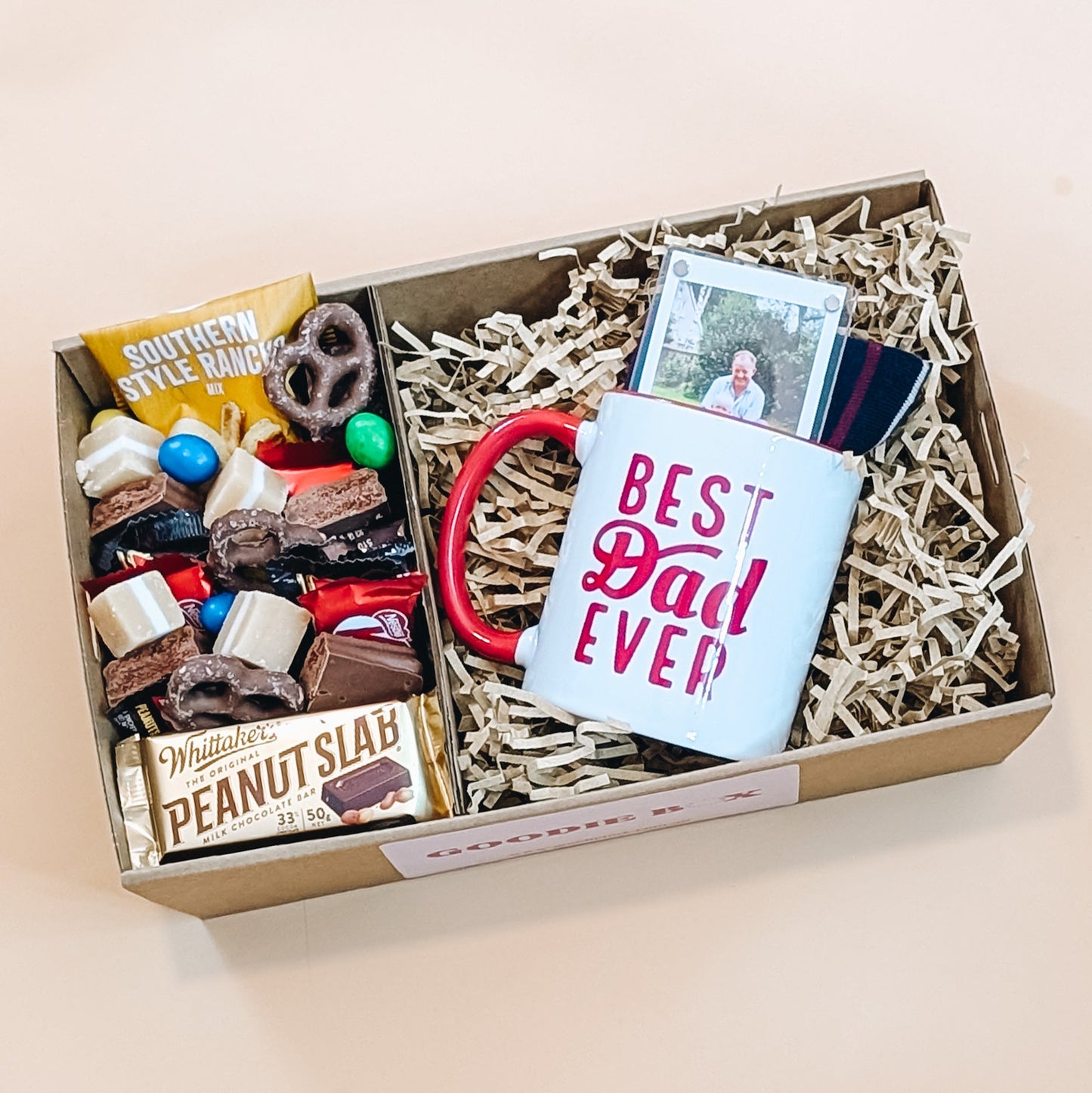 Fathers day gift box with a mug saying 'Best Dad Ever' and various items on a beige background
