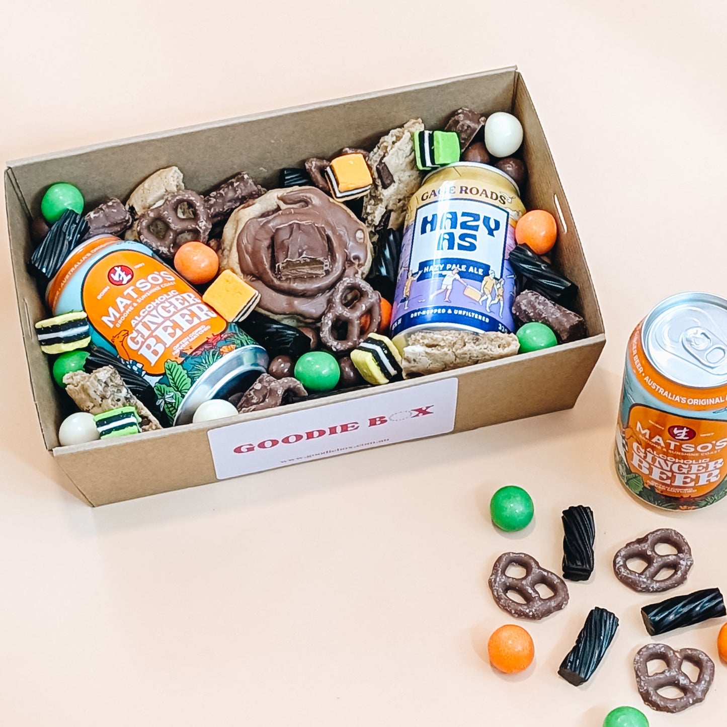 fathers day dessert box of snacks and a can of beer with 'Goodie box' label on a beige background