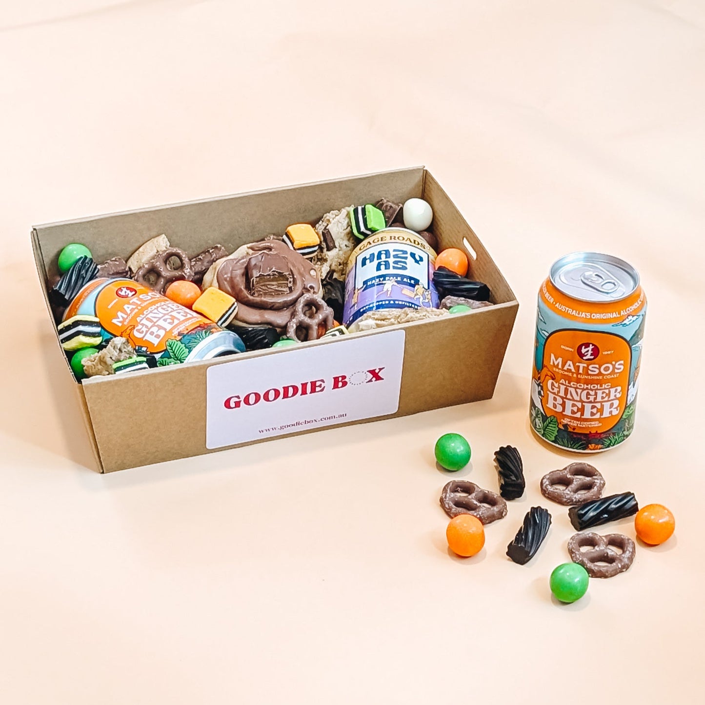 Goodie box with snacks and a can of beer on a beige background
