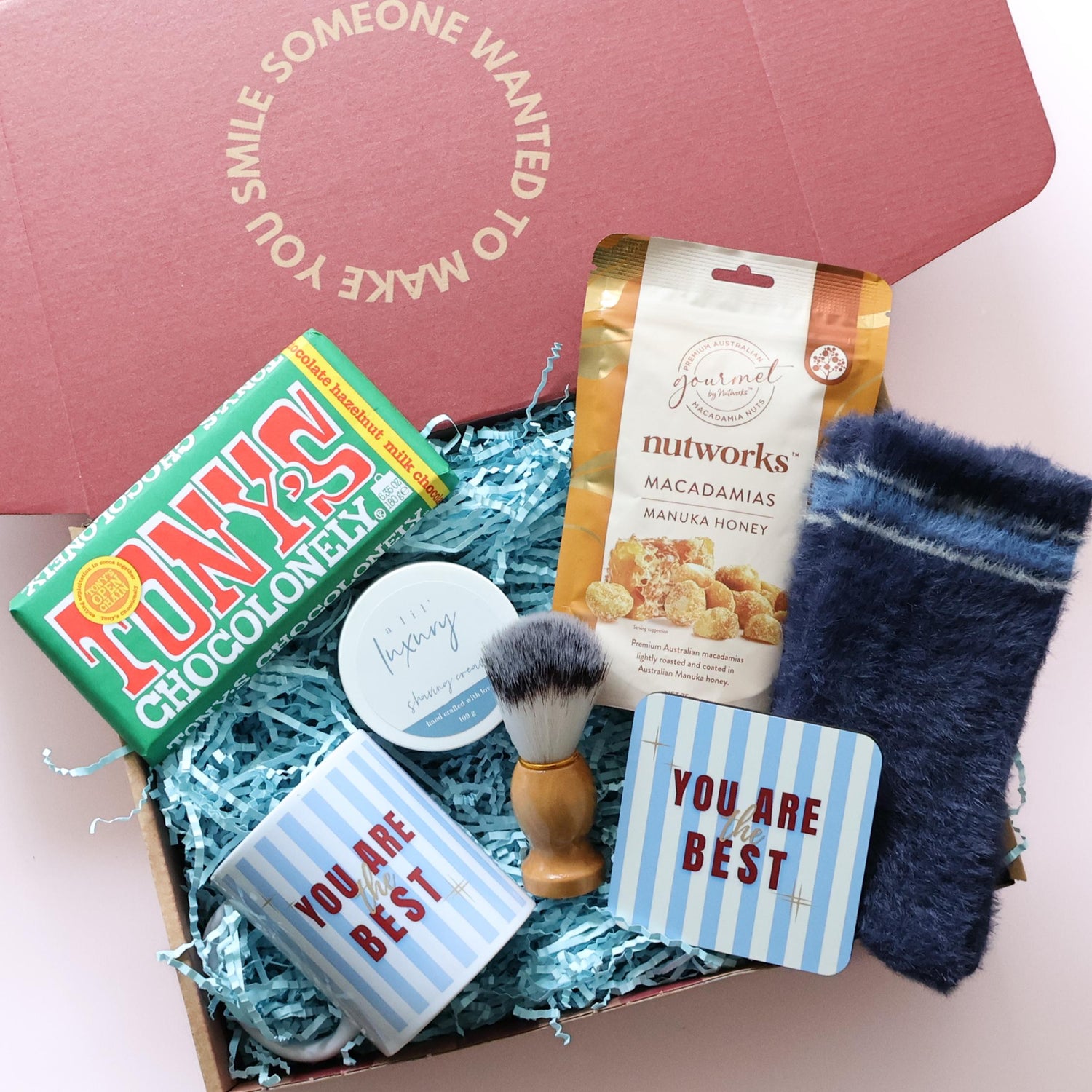 Photograph of agift box wrapped in a bow. The box is filled with chocolates and sweet treats.