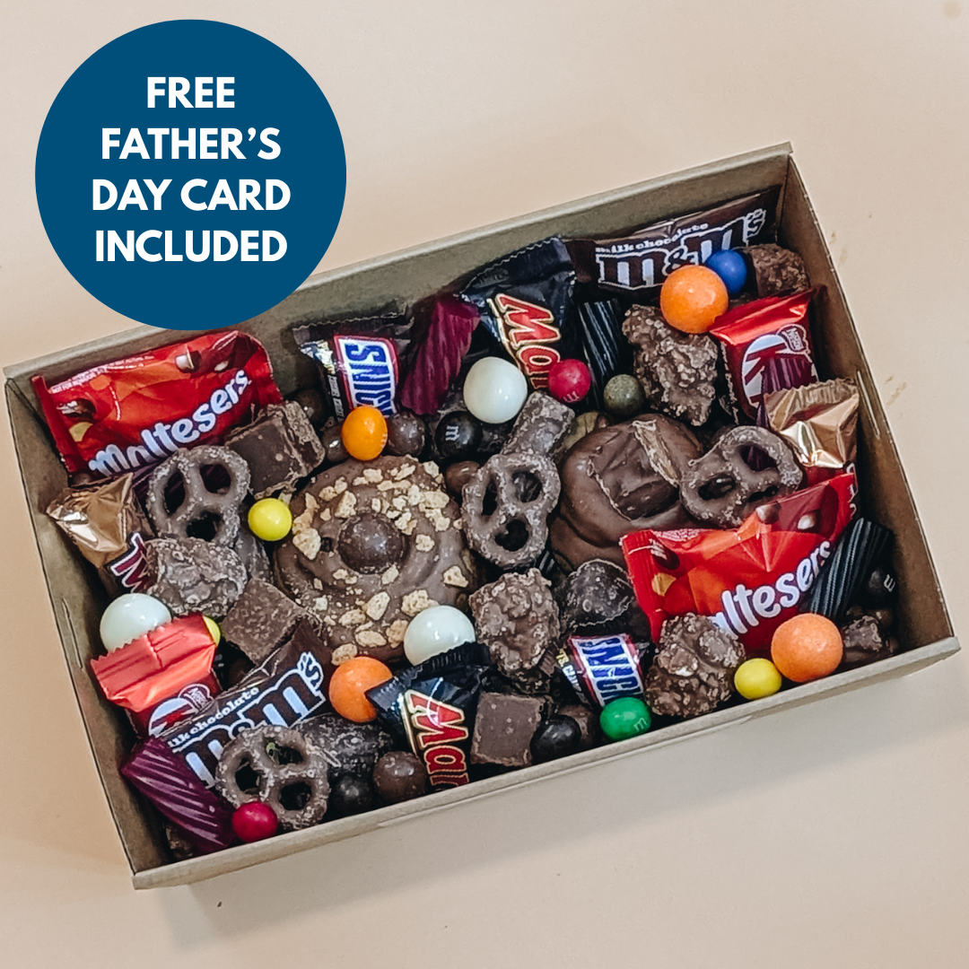 Box of assorted candy with a free Father's Day card included on a beige background