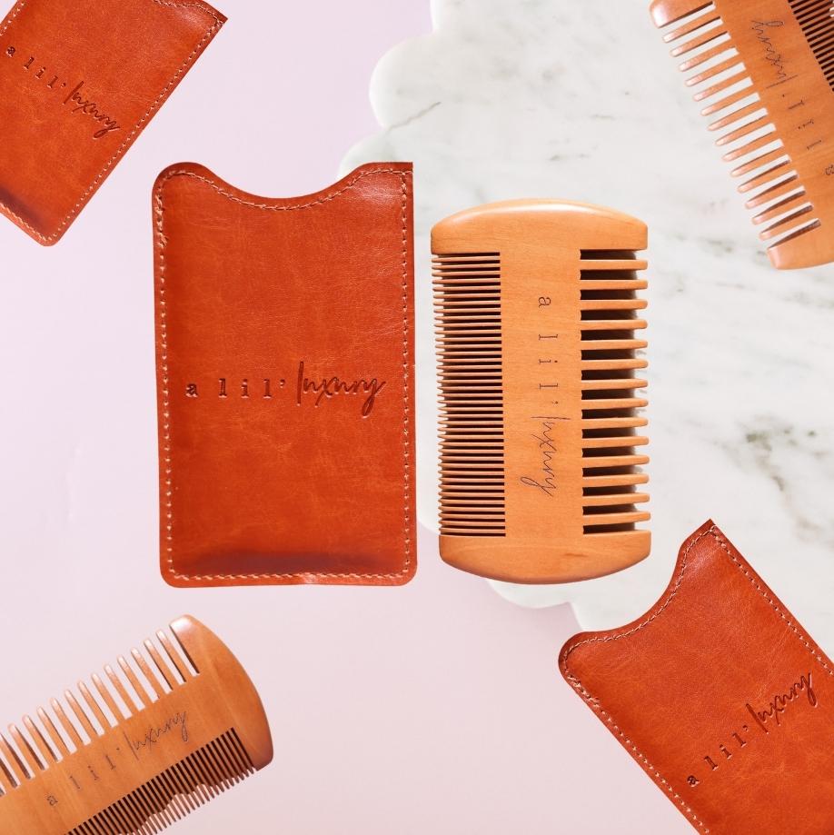 A Lil Luxury engraved wooden beard comb with tan case flatlay on pink background – Goodie Box gift box add-on Perth