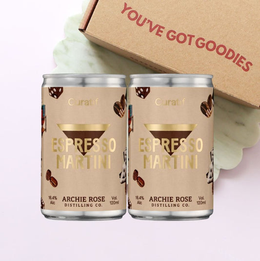Two cans of Espresso Martini by Archie Rose Distilling Co. with a cardboard box in the background.