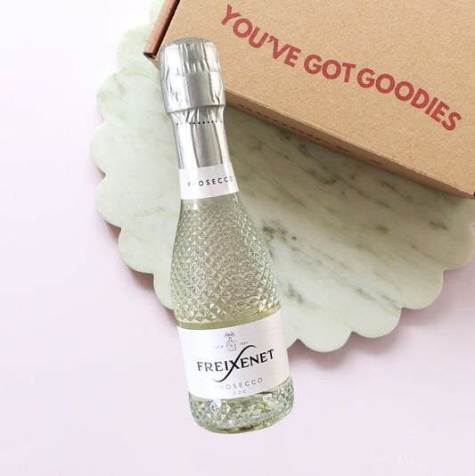 Bottle of Freixenet Prosecco with a 'You've Got Goodies' box on a light pink background