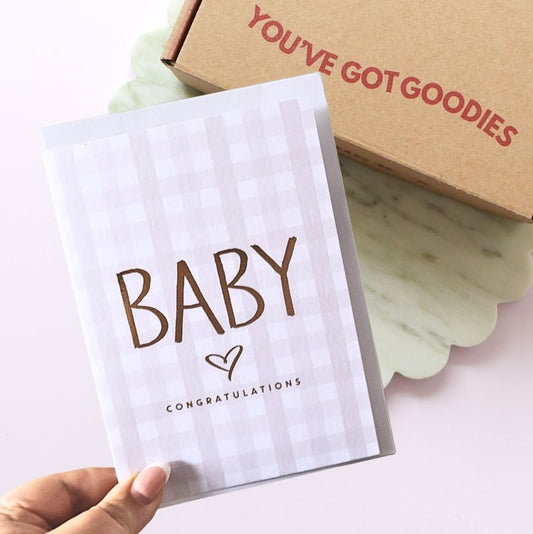 Card with 'Baby Congratulations' text held by a hand, next to a box with 'You've Got Goodies' text.