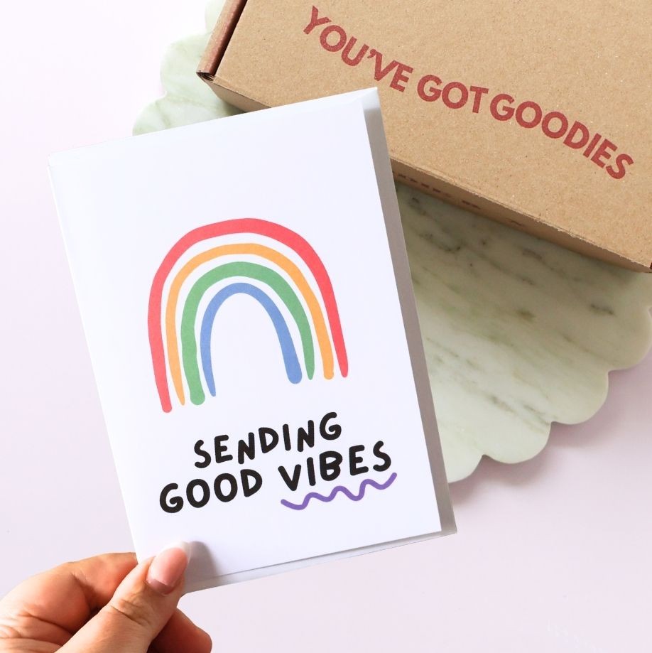 sending good vibes greeting card with a colourful rainbow drawing. A gift box in the background reading you've got goodies