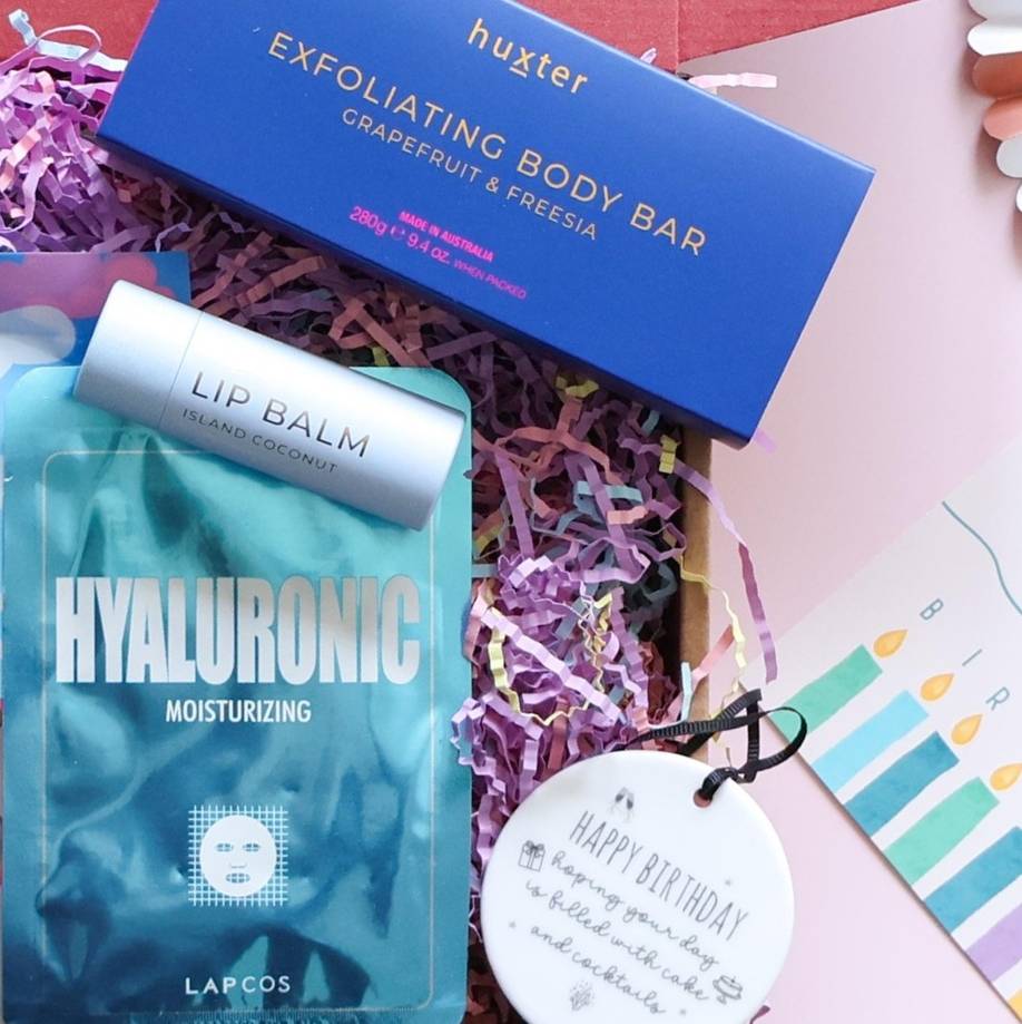 Birthday pamper gift box detail showing Huxter exfoliating body bar Lapcos hyaluronic face mask island coconut lip balm and birthday ceramic disc keepsake Perth