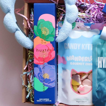 Birthday pamper gift box detail showing Huxter hand and body cream Candy Kittens Wanderlust gourmet chews and blue cloud spa headband Perth