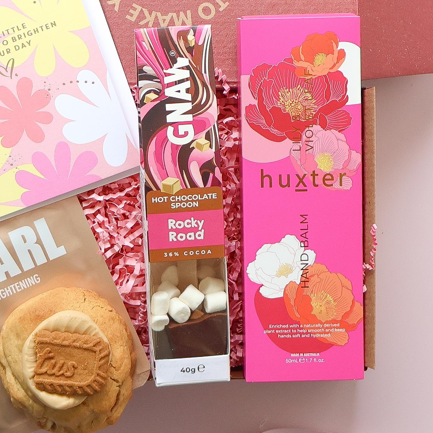 Self care gift box with Huxter hand balm, Gnaw rocky road hot chocolate spoon and biscoff stuffed cookie