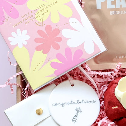 Close up of congratulations gift box greeting card, ceramic keepsake tag and Lapcos face mask