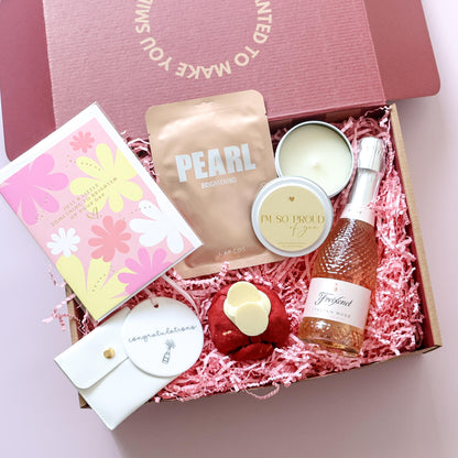 Congratulations gift box open showing sparkling rosé, Lapcos face mask, candle, cookie and keepsake tag