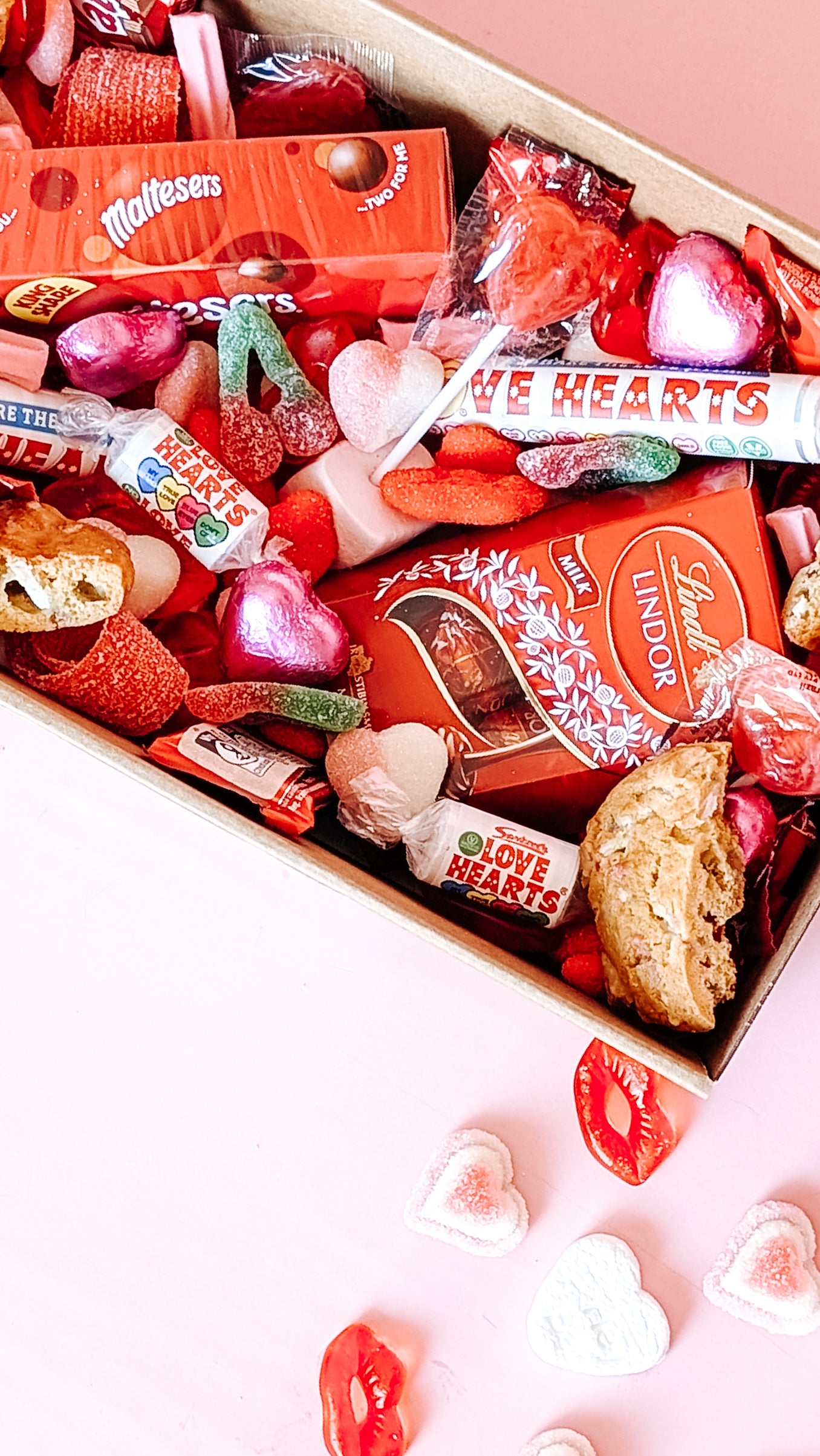Photograph of Galentines gift hamper. The dessert box is filled with and assortment of valentines themed chocolates, cookies and lollies.