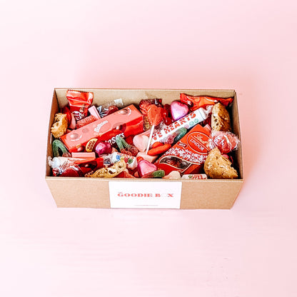 Photograph of Galentines gift hamper. The dessert box is filled with and assortment of valentines themed chocolates, cookies and lollies.