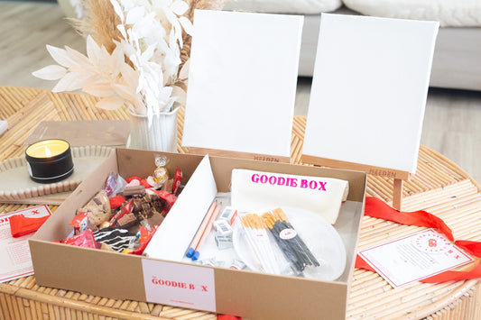 Goodie box with a painting kit and donuts on a table