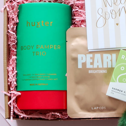 Huxter body pamper trio with pink packaging and 'Pearl Brightening' product