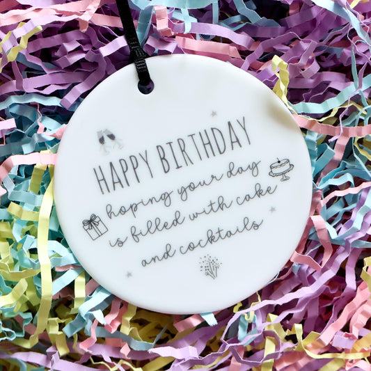 Round white ceramic ornament with 'Happy Birthday' text on colorful shredded paper