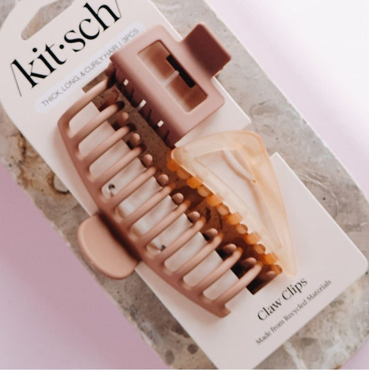 Kit-sch claw clips on a white card with a marble background