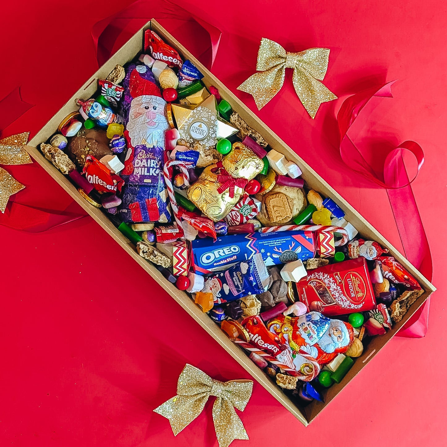 Assorted chocolate and candy box with Santa Claus design on a red background