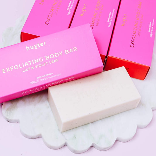 Lily and violet exfoliating body bar with pink packaging on a white surface