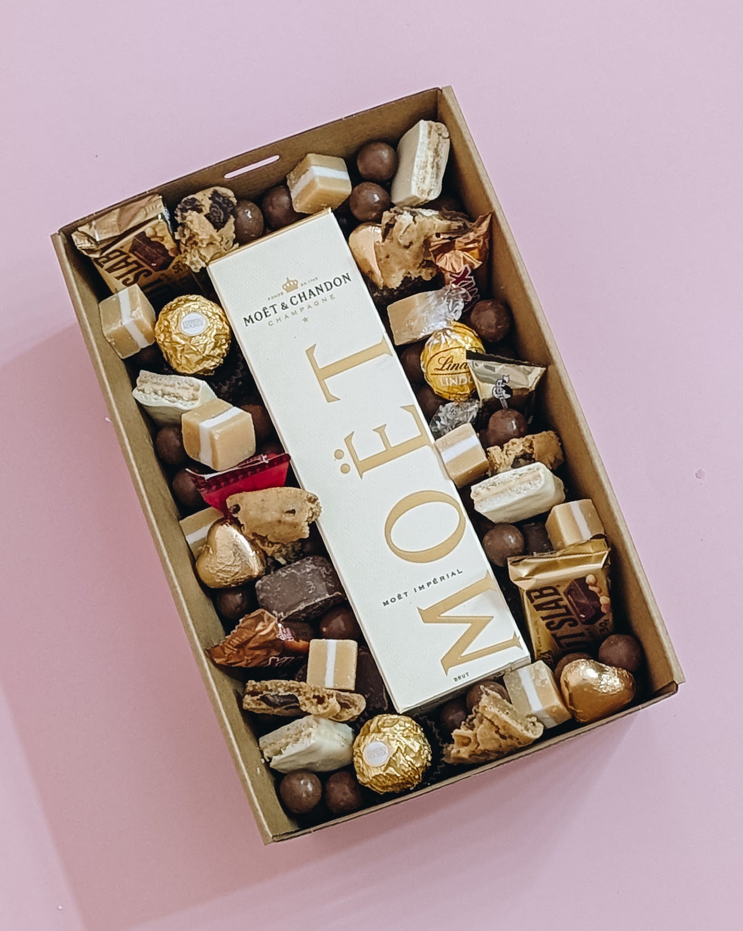 Photograph of Luxury Moët Champagne and chocolate gift hamper with personalized message. Wrapped with a beautiful gold bow ready for gifting. 
