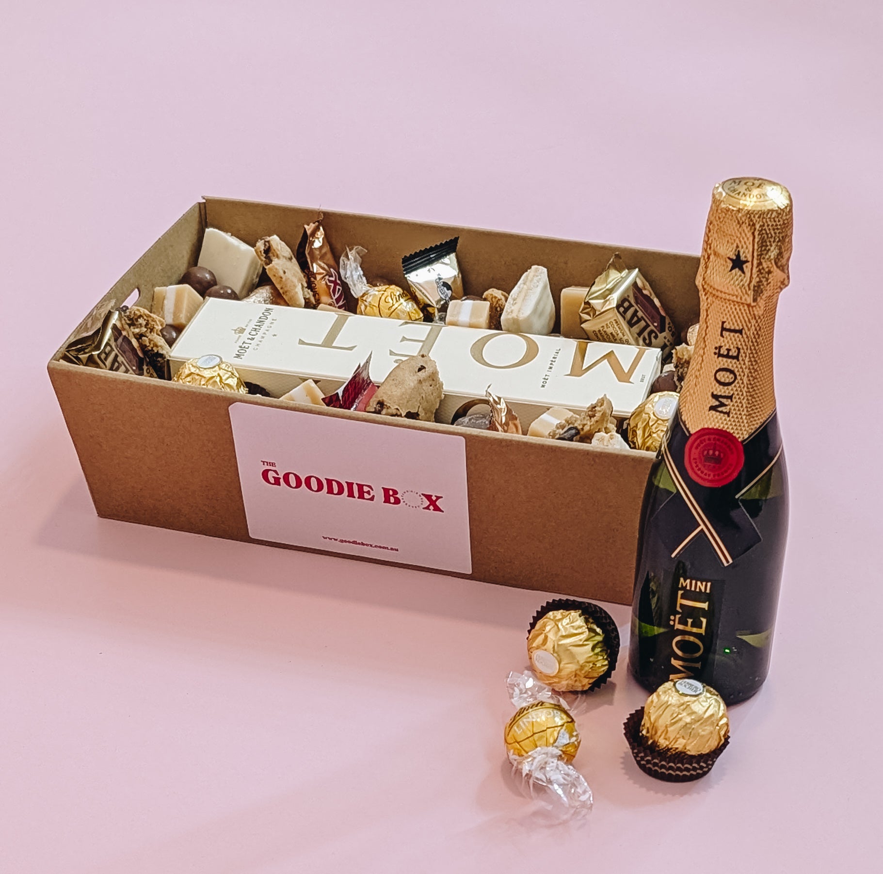 Photograph of Luxury Moët Champagne and chocolate gift hamper with personalized message. Wrapped with a beautiful gold bow ready for gifting. 