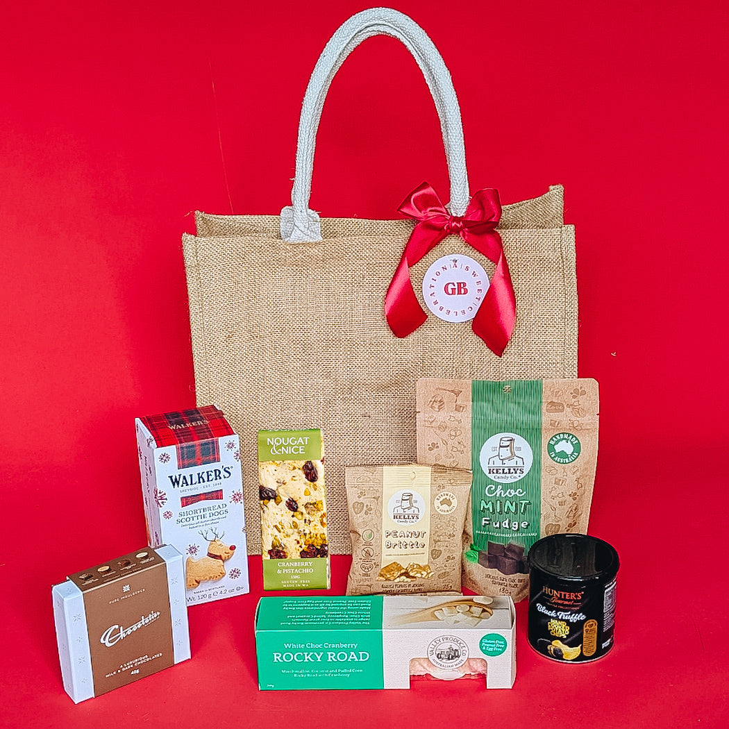 Tote bag with chocolate, shortbread and sweet good and chips on a red background.