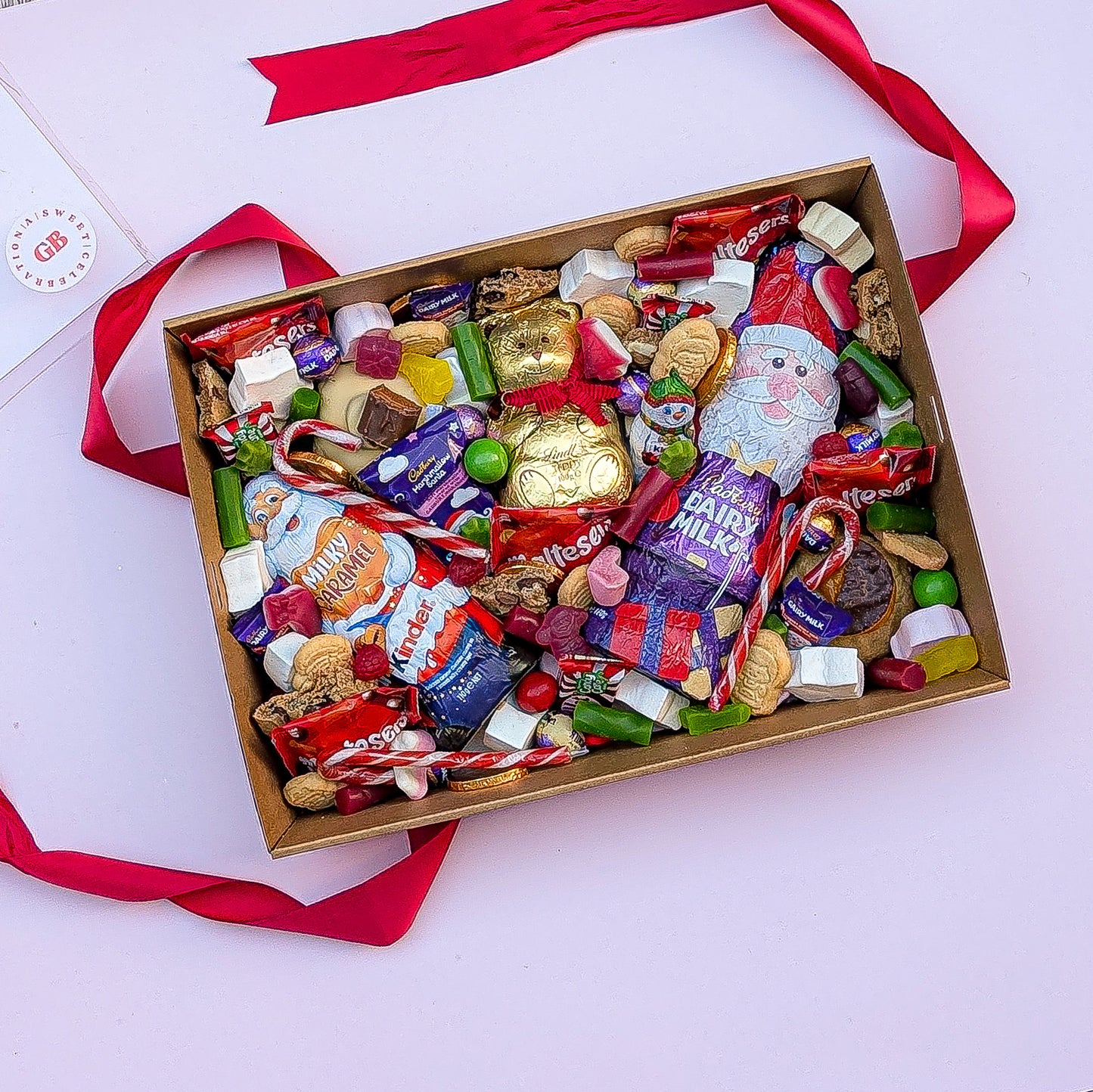 Box of assorted candies with a Santa Claus figure on a white background