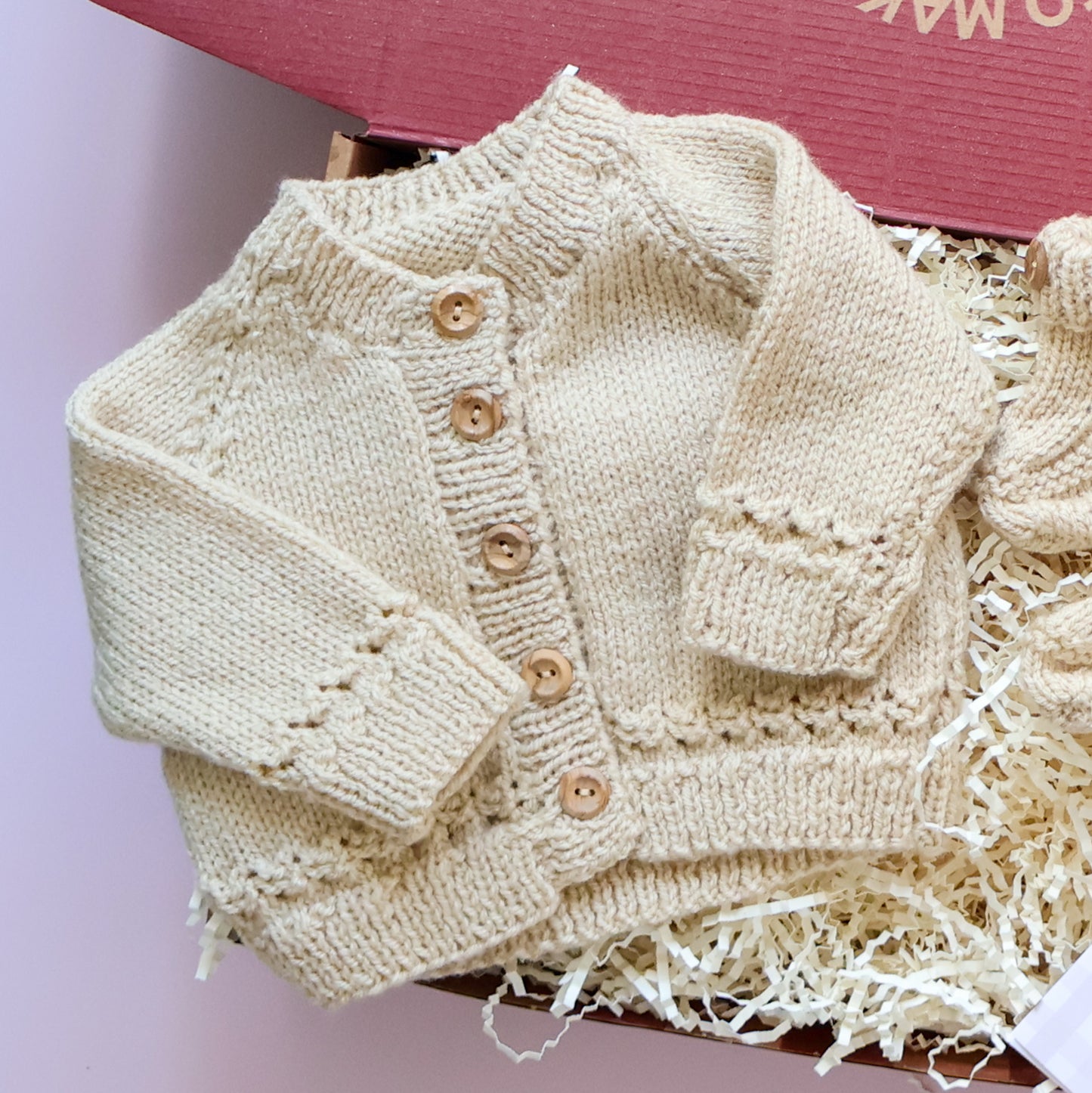 Mini knitted newborn gift box featuring hand knitted Scottish baby cardigan with wooden buttons