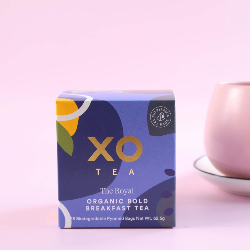 Box of XO Tea with a pink teacup on a light purple background
