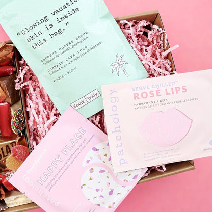 Flatlay of Pamper Hamper for Her— Frank Body coconut scrub, skincare and sweet treats Perth