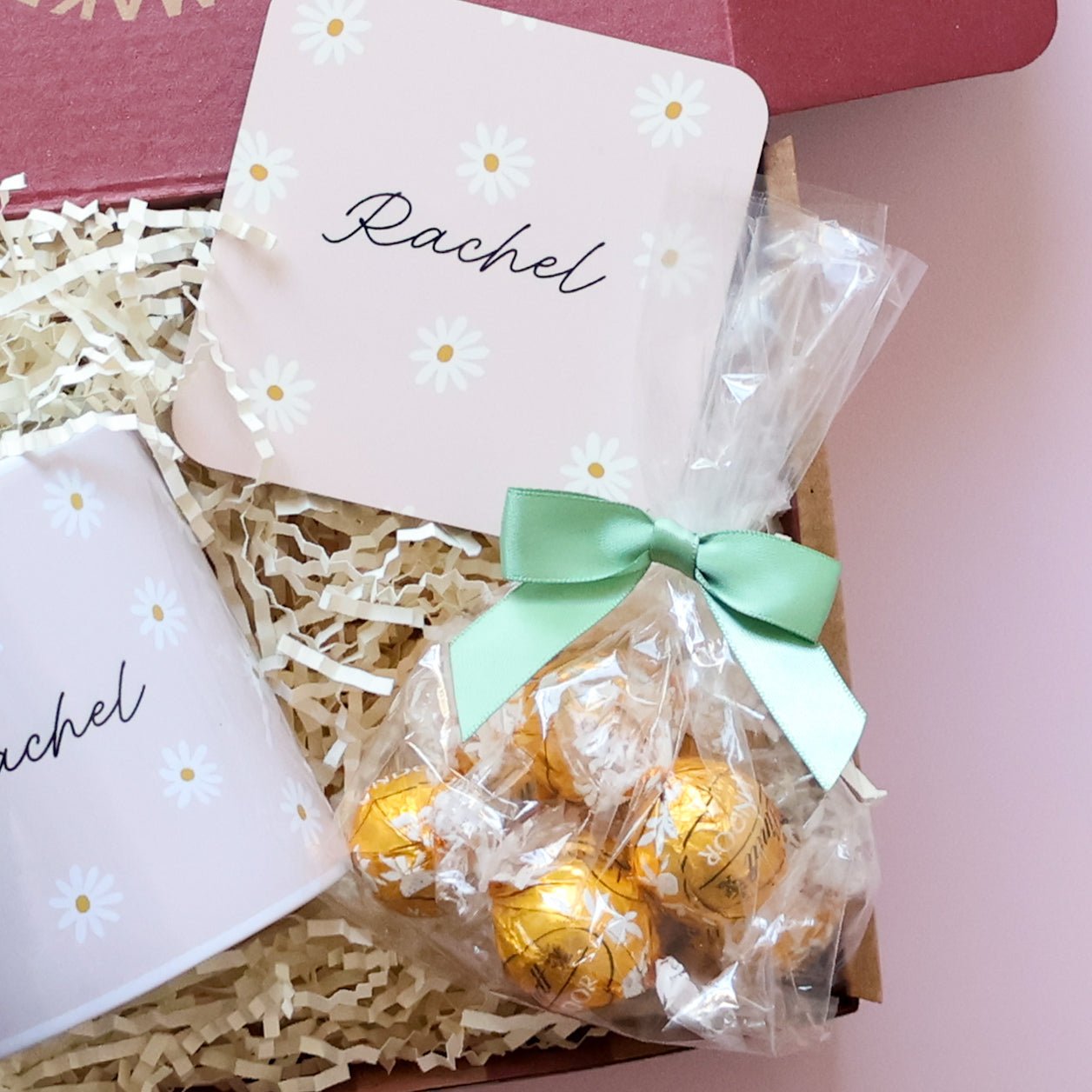 Close up of personalised daisy coaster and Lindt Lindor gold chocolates with green bow in personalised gift set for her
