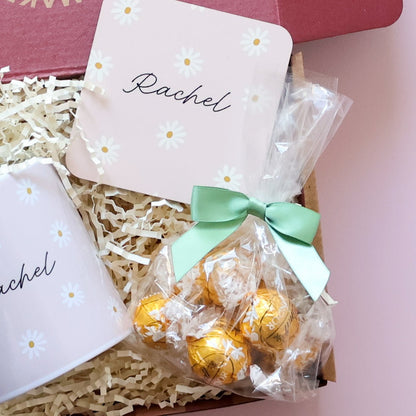 Close up of personalised daisy coaster and Lindt Lindor gold chocolates with green bow in personalised gift set for her