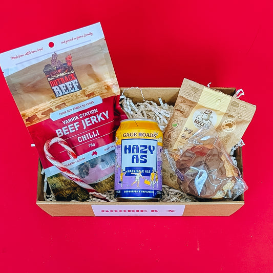 corporate gift box with beef jerkie, pale ale peanut brittle and cookie on a red background.