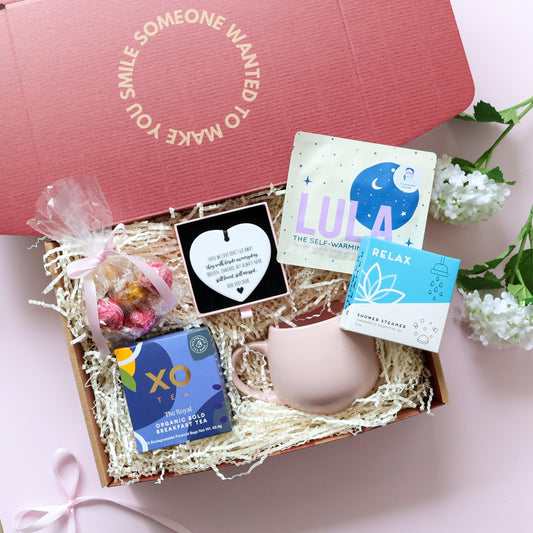 With Sympathy gift box Perth open showing XO Tea pink tulip mug Lindt Lindor chocolates Lula self warming eye mask Relax shower steamer and ceramic heart keepsake