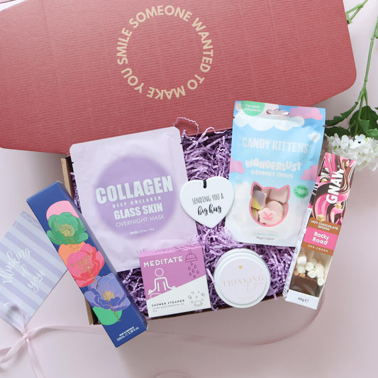 Pamper Gift Box showing Huxter body cream Lapcos face mask shower steamer Candy Kittens chews Gnaw hot chocolate spoon candle and ceramic keepsake