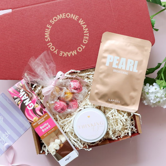 Comfort gift hamper showing hot chocolate Lindt chocolates Lapcos brightening face mask and Thinking of You soy candle tin