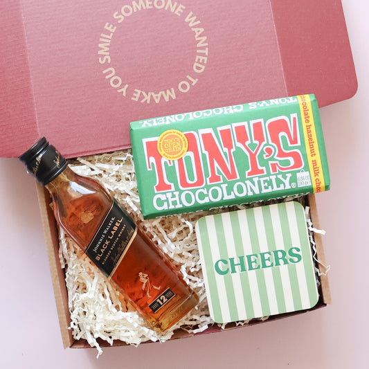Close up of Tony's Chocolonely chocolate hazelnut and Cheers stripey coaster in thoughtful gift for him 