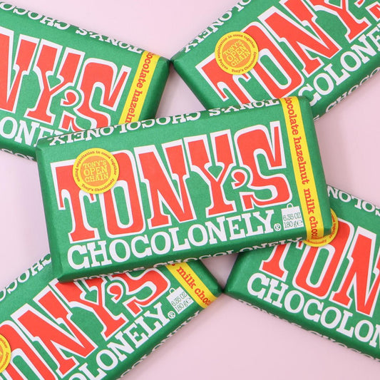 Multiple Tony's Chocolonely chocolate bars on a light pink background