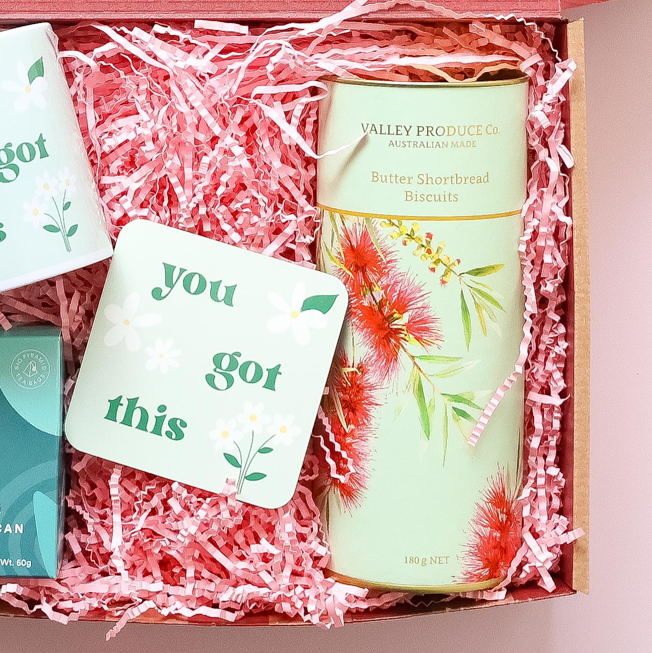 Get well soon care package detail showing You Got This coaster XO Tea peppermint and Valley Produce Co butter shortbread biscuits